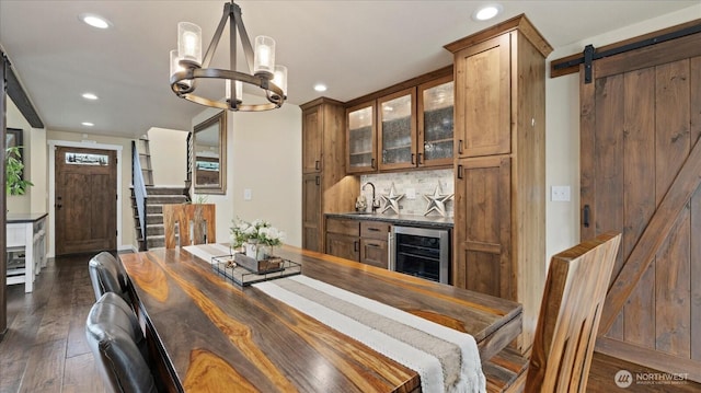 dining space with a barn door, wine cooler, dark wood-style flooring, and recessed lighting