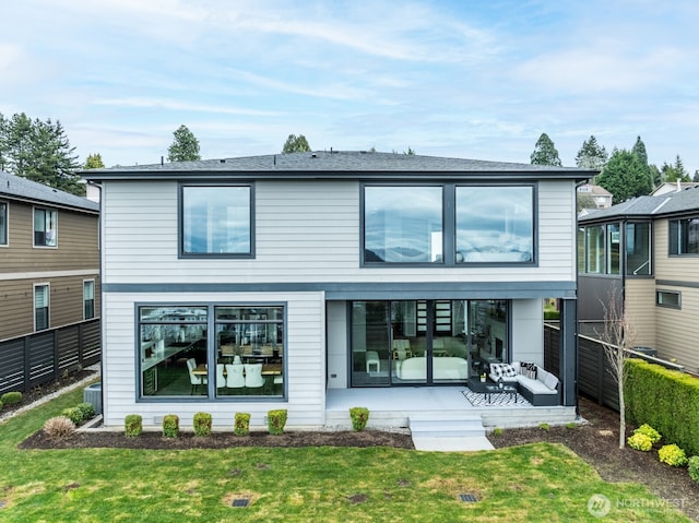 back of house featuring a sunroom, a fenced backyard, and a yard