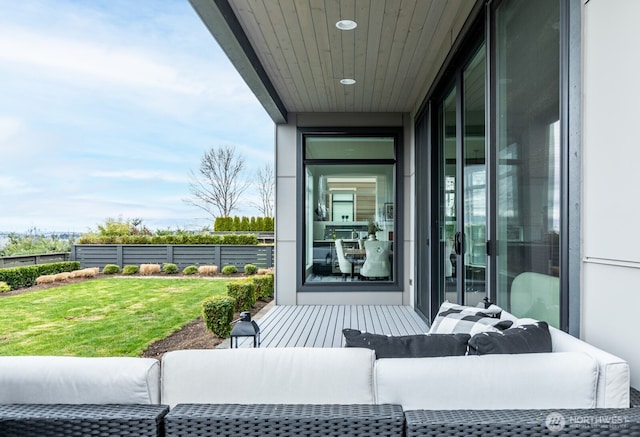 doorway to property featuring fence, an outdoor hangout area, and a lawn