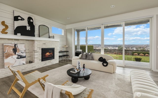 living area featuring a brick fireplace and wood finished floors