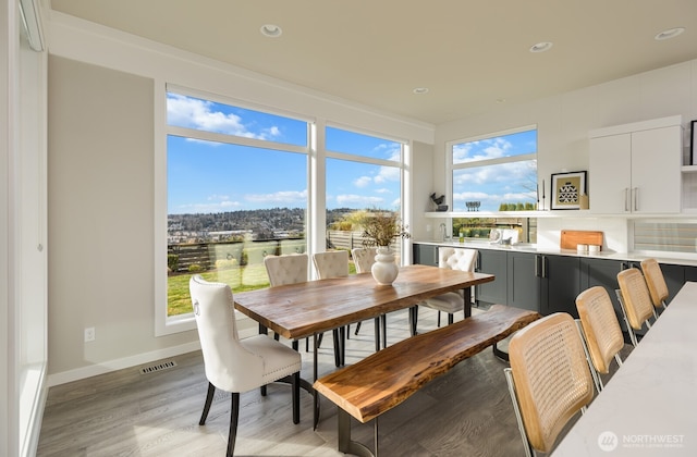 dining room featuring light wood-type flooring, baseboards, visible vents, and recessed lighting