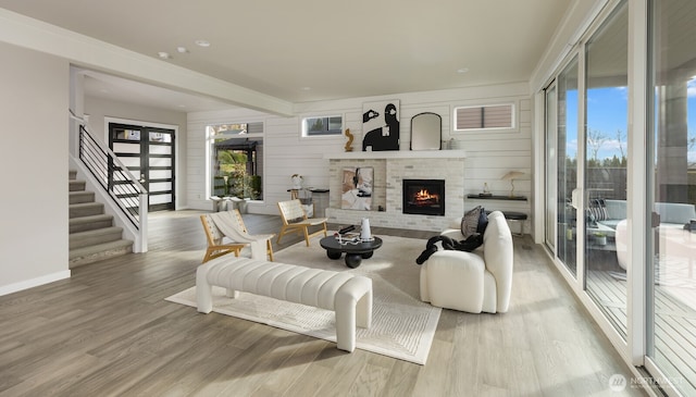 living room featuring light wood-type flooring, a fireplace, and a wealth of natural light