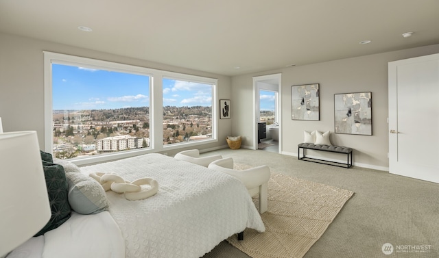 bedroom with carpet floors, ensuite bath, and baseboards