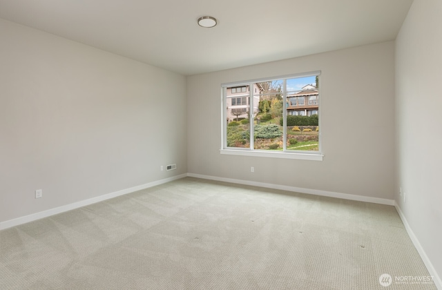 unfurnished room with light carpet, visible vents, and baseboards