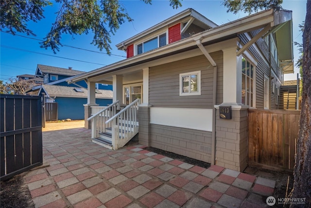 view of front of house with a patio area and fence