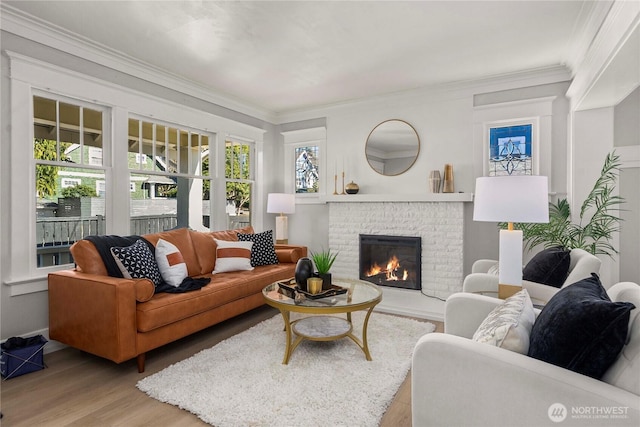 living room with a brick fireplace, ornamental molding, and wood finished floors