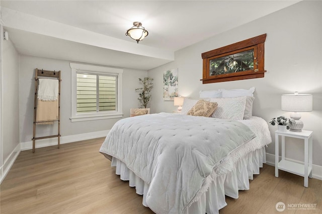 bedroom featuring baseboards and wood finished floors