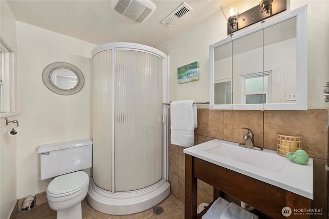 full bath featuring toilet, a shower stall, visible vents, and tile patterned flooring