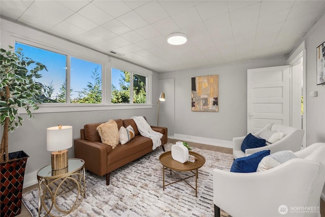 living room featuring baseboards, visible vents, and wood finished floors