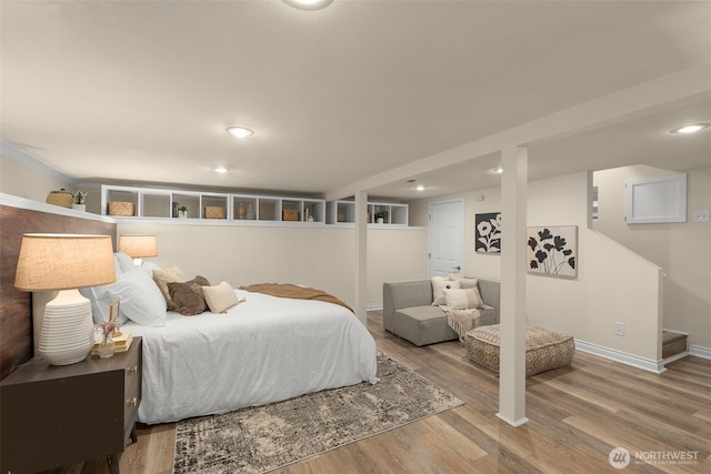 bedroom with baseboards, wood finished floors, and recessed lighting