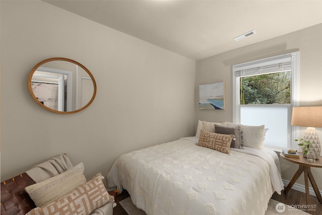 bedroom featuring visible vents and wood finished floors