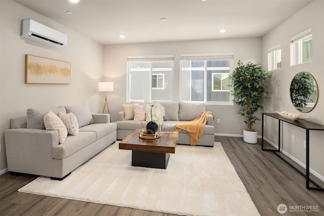 living room with an AC wall unit, recessed lighting, wood finished floors, and baseboards