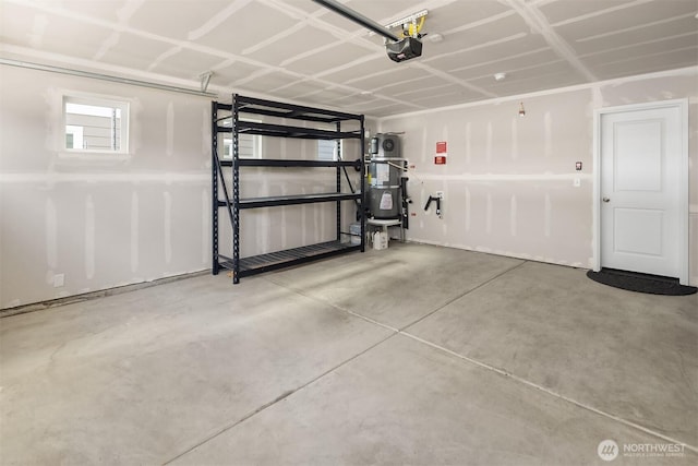 garage with strapped water heater and a garage door opener