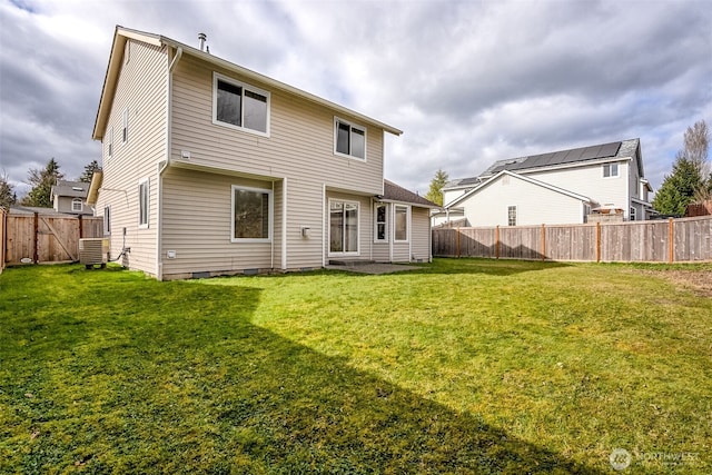 rear view of house with a fenced backyard, central AC unit, and a yard