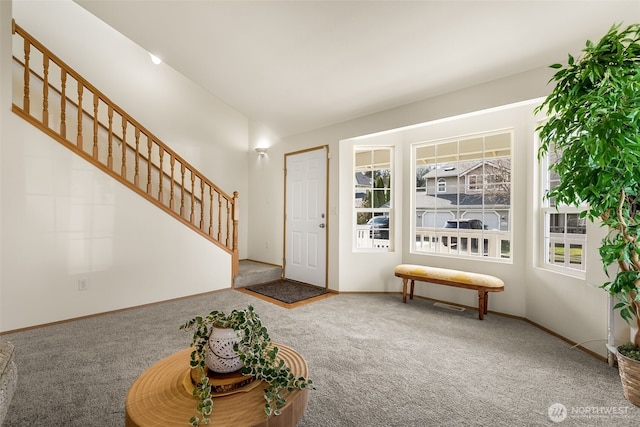 foyer entrance featuring lofted ceiling, stairs, baseboards, and carpet flooring