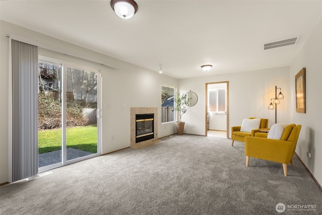 sitting room featuring carpet, plenty of natural light, visible vents, and a tile fireplace