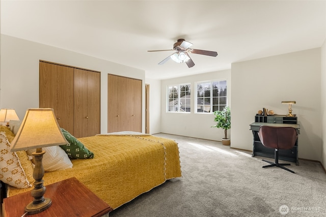 bedroom with carpet, a ceiling fan, and multiple closets