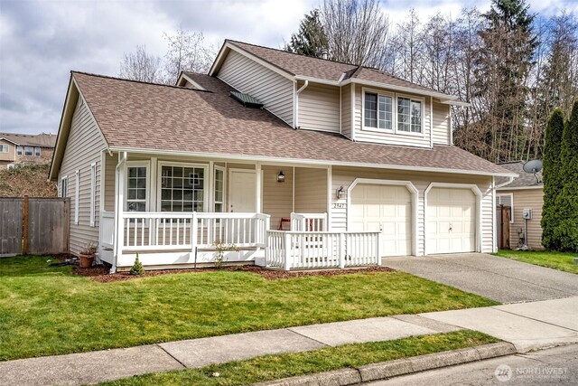 traditional home with roof with shingles, a porch, concrete driveway, an attached garage, and a front lawn