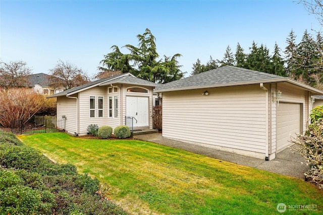 ranch-style house featuring a garage, an outdoor structure, fence, and a front lawn