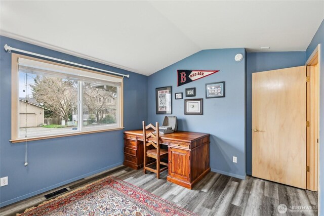 office featuring vaulted ceiling, wood finished floors, visible vents, and baseboards