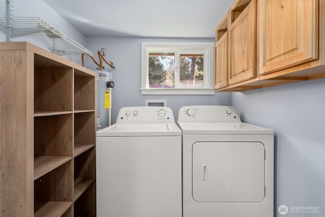 clothes washing area featuring cabinet space and washing machine and dryer