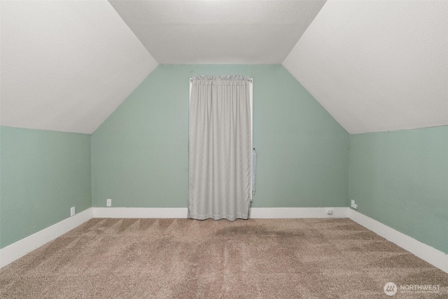 additional living space with vaulted ceiling, carpet, and baseboards