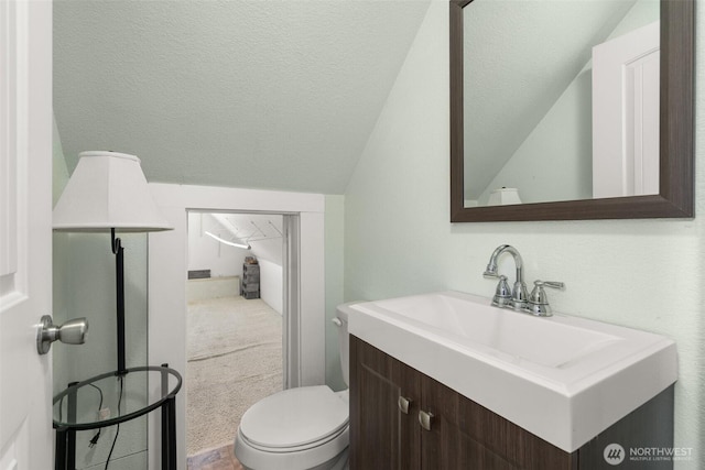 bathroom with lofted ceiling, toilet, a textured ceiling, and vanity