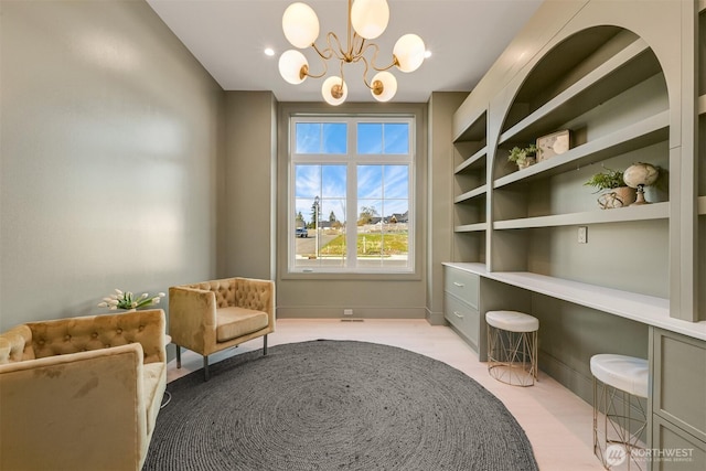 living area with baseboards and a chandelier