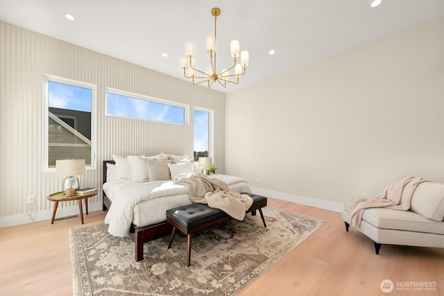 bedroom with baseboards, a notable chandelier, and light wood finished floors