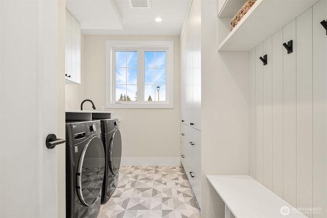 washroom featuring visible vents, independent washer and dryer, cabinet space, baseboards, and light floors