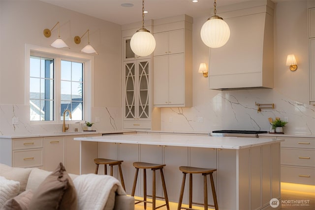 kitchen featuring white cabinets, backsplash, a kitchen breakfast bar, and a center island