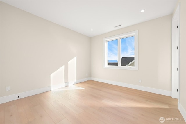 unfurnished room with recessed lighting, light wood-style flooring, visible vents, and baseboards