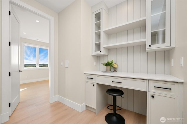 bar featuring light wood-type flooring and baseboards