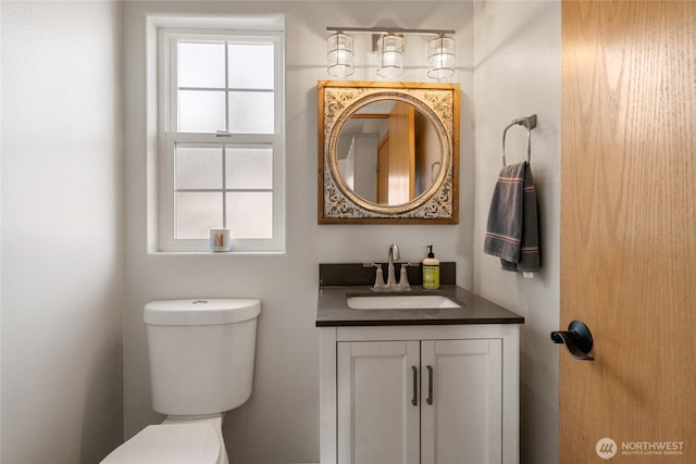 bathroom with vanity, toilet, and a healthy amount of sunlight