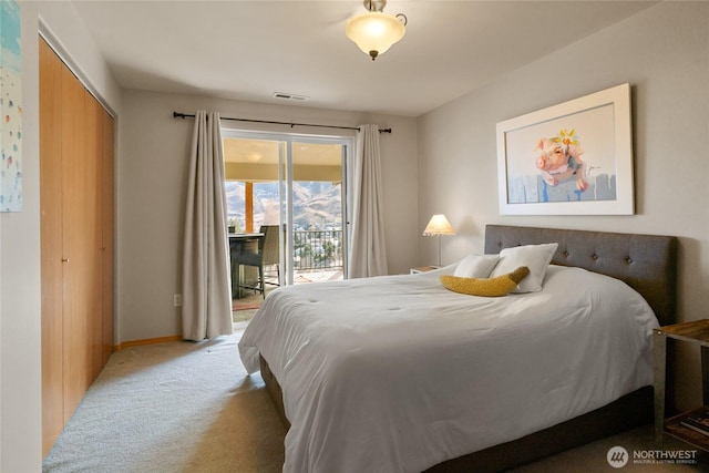 carpeted bedroom featuring access to outside, a closet, visible vents, and baseboards