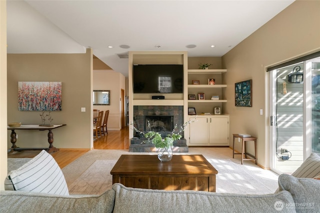 living area with visible vents, a fireplace, and light wood-style flooring