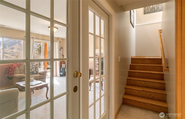 doorway to outside with french doors, stairway, and carpet