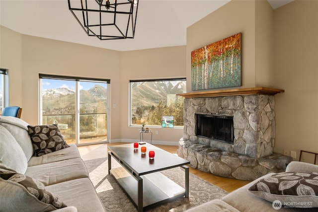 living area featuring light wood-style floors, a fireplace, and baseboards