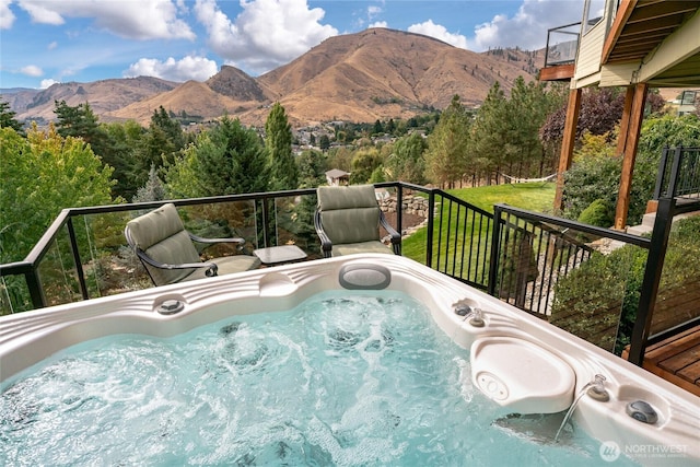 view of swimming pool with a mountain view and a hot tub