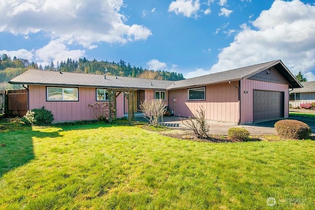 ranch-style house featuring a front yard, concrete driveway, and an attached garage