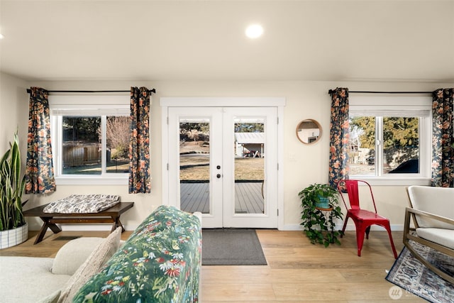 interior space with french doors, baseboards, and light wood finished floors