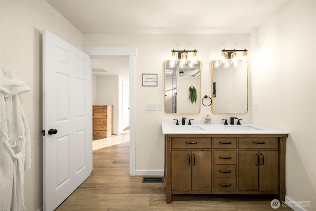 full bath featuring visible vents, a sink, and wood finished floors