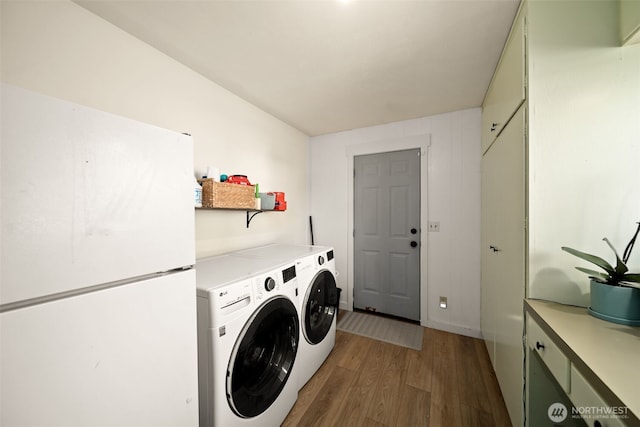 laundry area featuring laundry area, wood finished floors, and washing machine and dryer