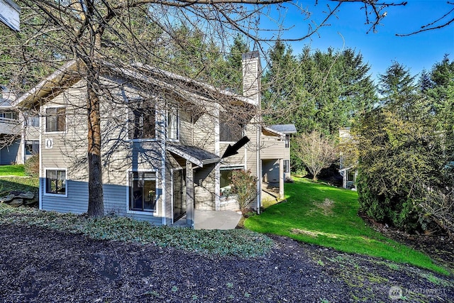 exterior space with a chimney and a front yard