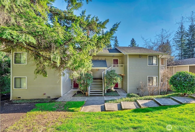 view of front of house featuring crawl space, stairway, and a front lawn