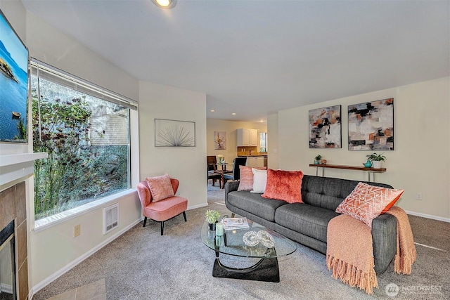 living room with baseboards, visible vents, a glass covered fireplace, carpet, and recessed lighting