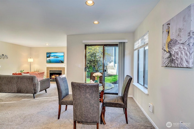 carpeted dining area with a tile fireplace, baseboards, and recessed lighting