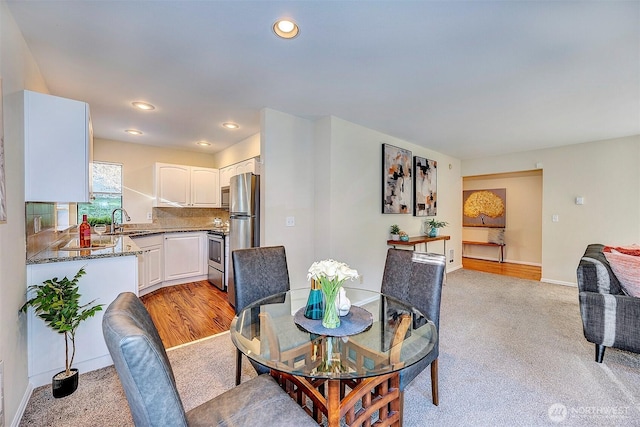 dining area with baseboards, recessed lighting, and light colored carpet