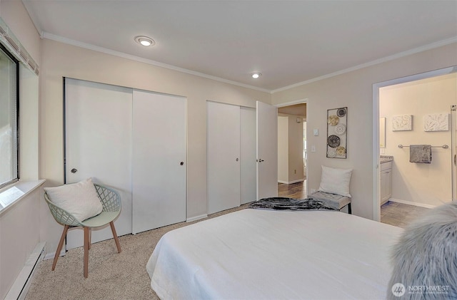 bedroom with crown molding, multiple closets, a baseboard heating unit, ensuite bath, and baseboards