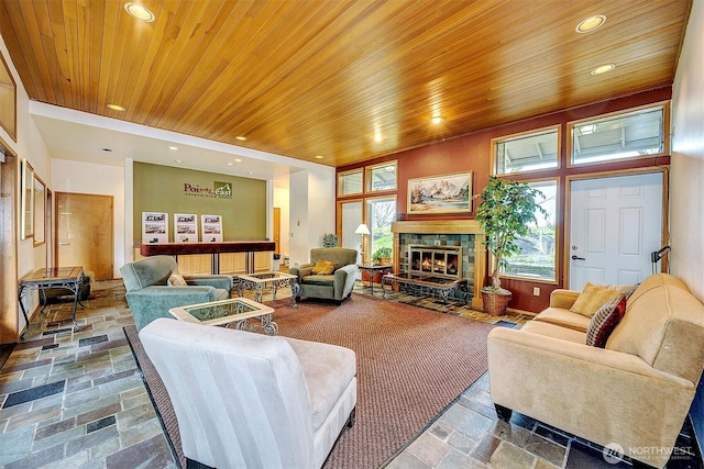 living area featuring recessed lighting, wooden ceiling, a fireplace, and stone tile floors